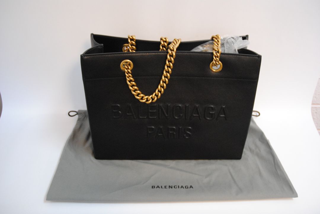 Black Balenciaga Medium Shopping Tote in Black Calfskin Leather with Aged Gold Chain, Length: 13.8 in (35 cm) Height: 11.8 in (30 cm) Depth: 5.5 in (14 cm) Strap Drop: 11 in