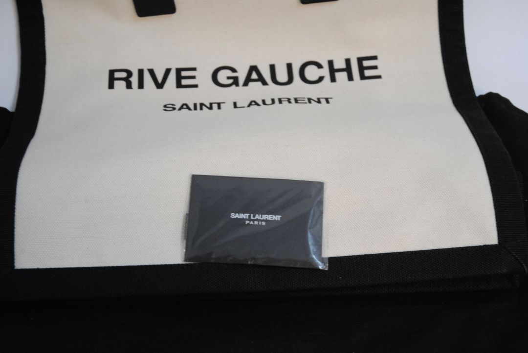 Black and White Yves Saint Laurent Rive Gauche Tote in Canvas and Leather, Length: 18.5 in (47 cm) Height: 14.2 in (36 cm) Width: 6.7 in (17 cm) Strap Drop: 17 in (removable shoulder strap) Handle Drop: 5 in