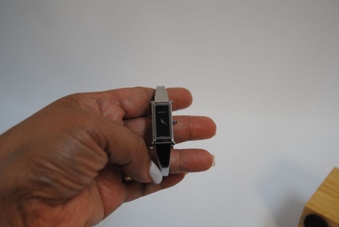 black and silver Gucci rectangle bangle watch, Case Dimensions: Approx. 15 mm width x 35 mm height Band Width: Approx. 10 mm
