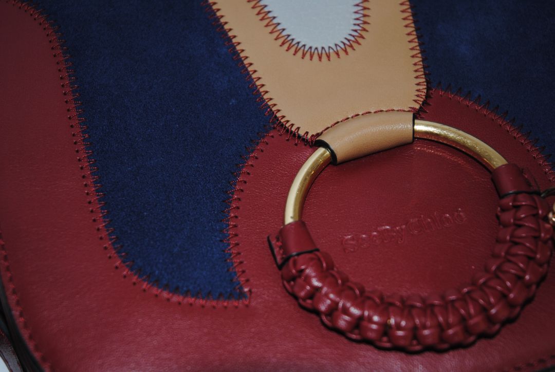 Body: Navy blue suede Trim & Strap: Burgundy and camel-toned smooth leather See by Chloe Hana Small Saddle Bag, Width: 7.5 in (19 cm) Height: 6.5 in (16.5 cm) Depth: 2.75 in (7 cm) Strap Drop: Adjustable up to approx. 22 in (crossbody length)
