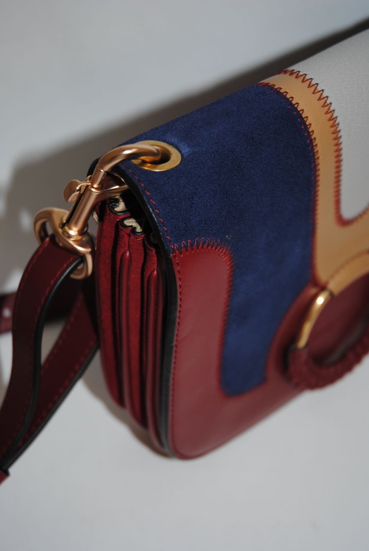 Body: Navy blue suede Trim & Strap: Burgundy and camel-toned smooth leather See by Chloe Hana Small Saddle Bag, Width: 7.5 in (19 cm) Height: 6.5 in (16.5 cm) Depth: 2.75 in (7 cm) Strap Drop: Adjustable up to approx. 22 in (crossbody length)