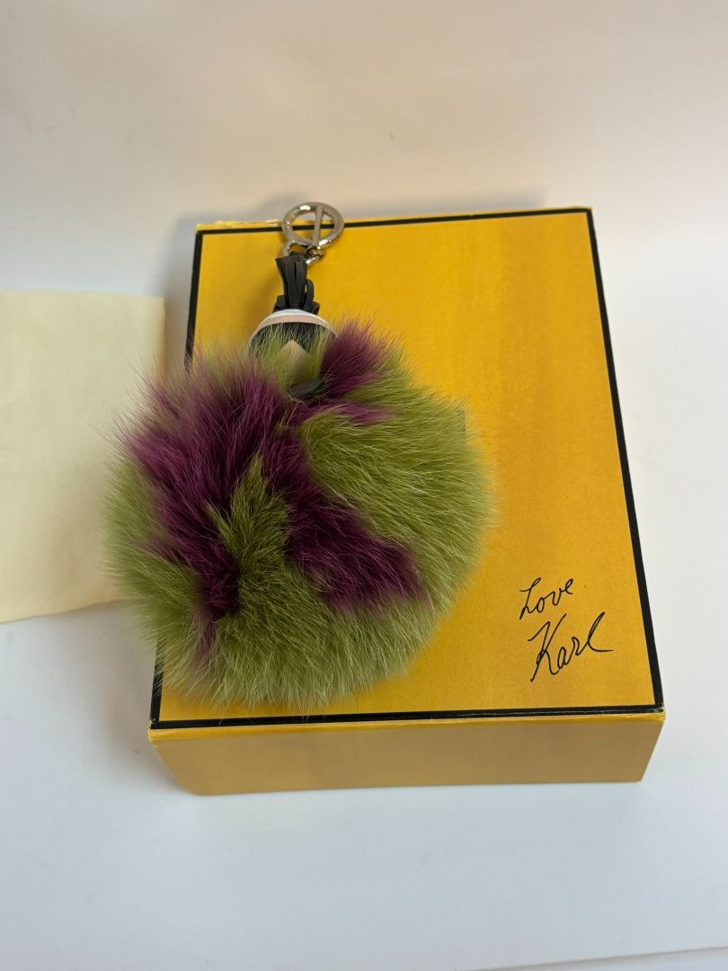 purple and green FENDI fur “monster” bag charm, pom-pom diameter: 10 cm (4 in) Total hanging drop (ring + strap + fur): ~20 cm (8 in)