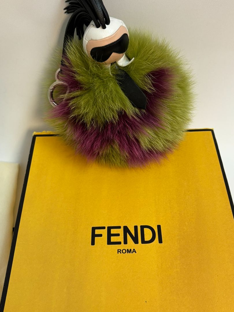 purple and green FENDI fur “monster” bag charm, pom-pom diameter: 10 cm (4 in) Total hanging drop (ring + strap + fur): ~20 cm (8 in)