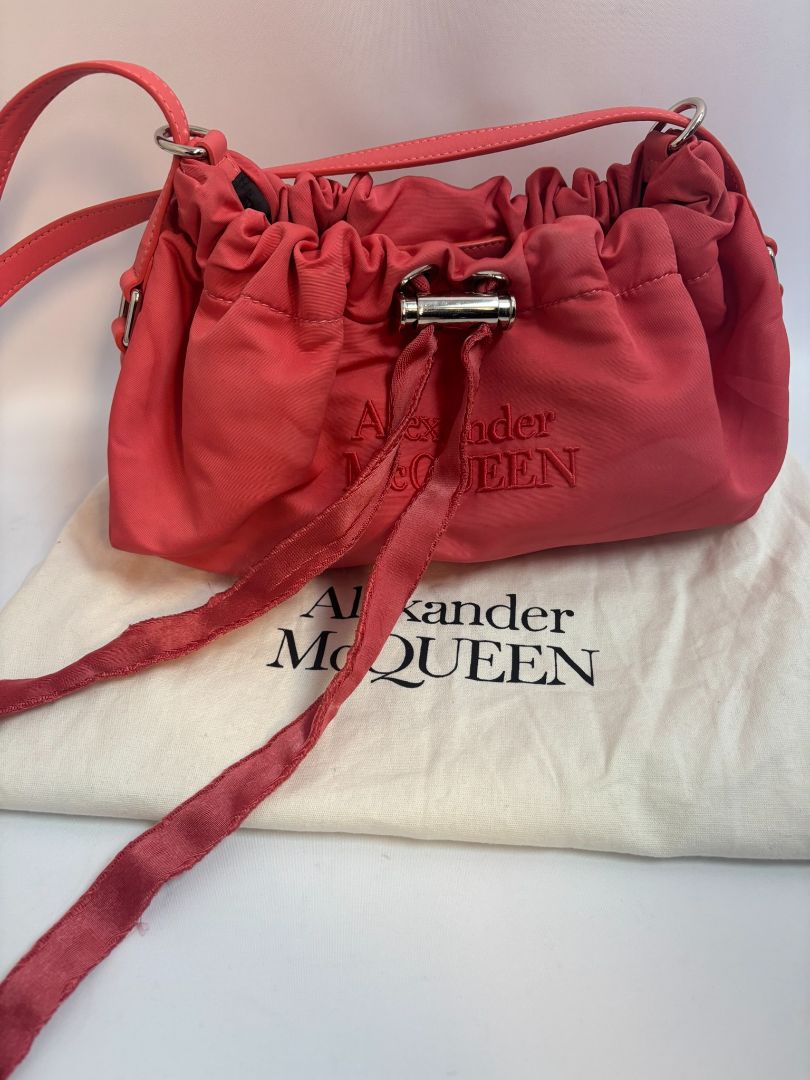 red Alexander McQueen drawstring bag, Length: 10 in Height: 6 in Depth: 3.5 in Strap Drop: Adjustable (approx. 12β20 in)