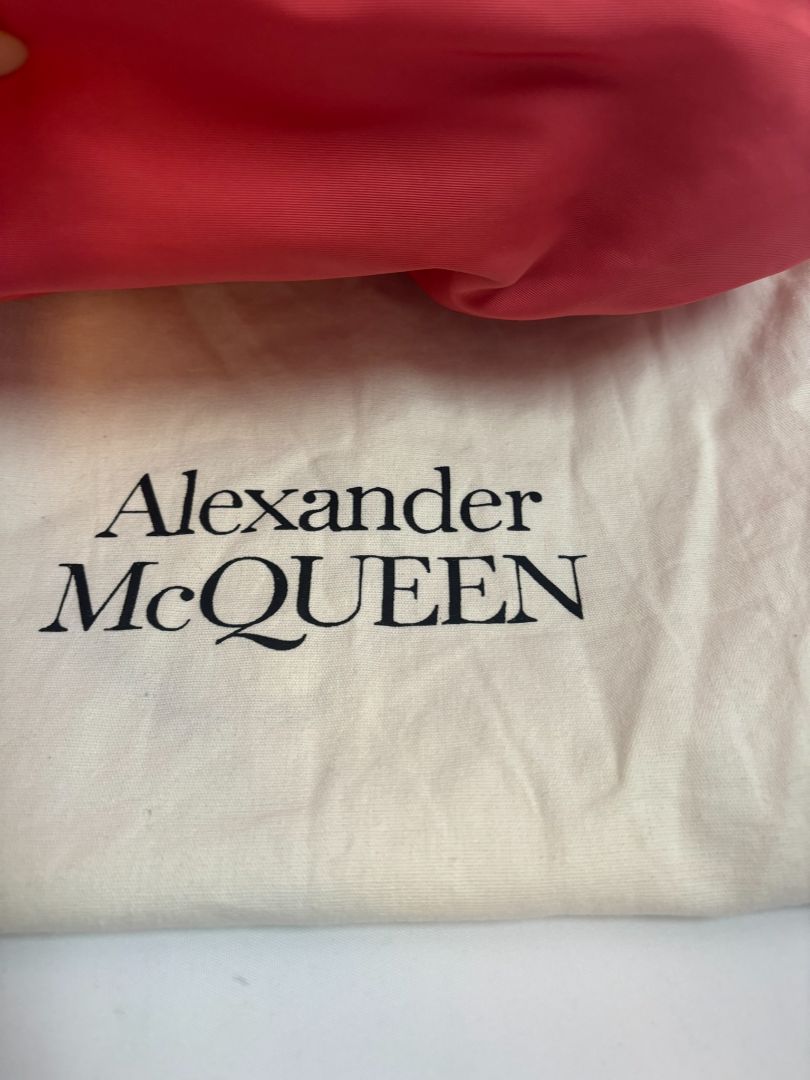 red Alexander McQueen drawstring bag, Length: 10 in Height: 6 in Depth: 3.5 in Strap Drop: Adjustable (approx. 12β20 in)