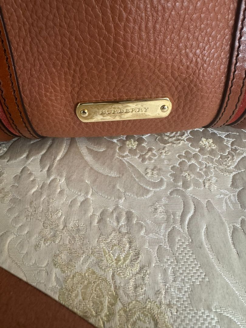 Cognac brown with multi-stripe accents in oxblood, black, and tan (subtle nod to Burberry’s house check palette) Burberry Model: Likely from the Banner or Orchard satchel line (structured silhouette with rolled handles and stripe accents), Length: 13 in (