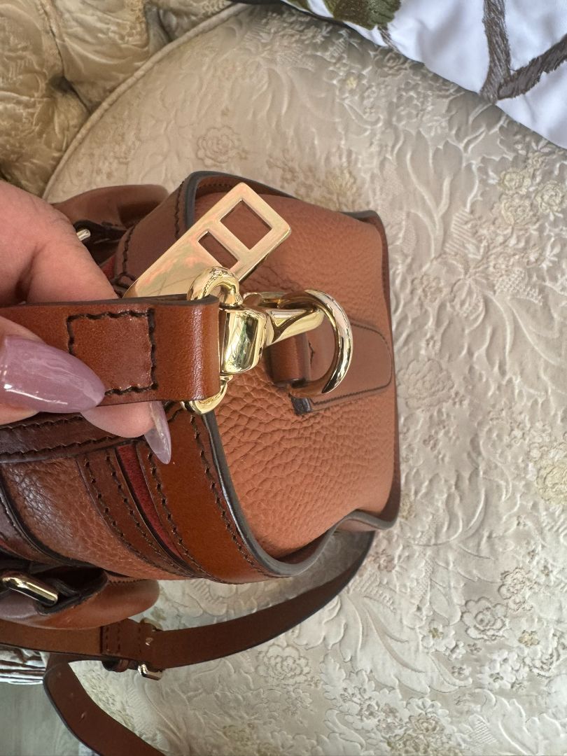Cognac brown with multi-stripe accents in oxblood, black, and tan (subtle nod to Burberry’s house check palette) Burberry Model: Likely from the Banner or Orchard satchel line (structured silhouette with rolled handles and stripe accents), Length: 13 in (