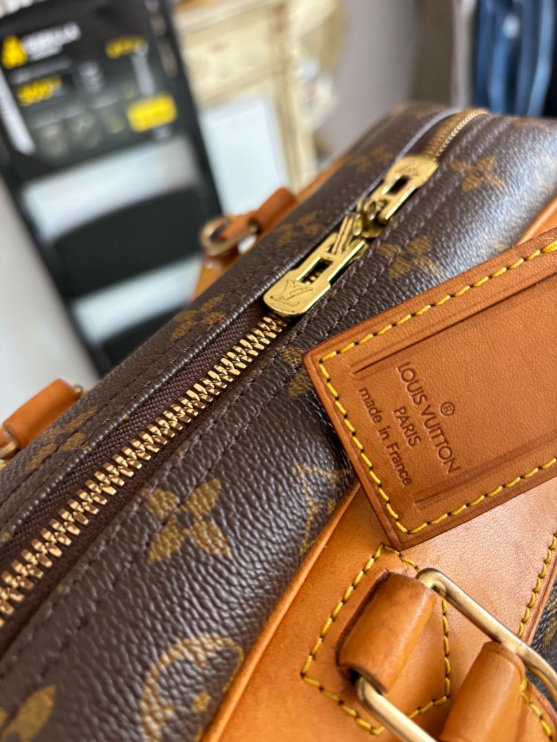 Close-up of LV monogram canvas, leather handles, and gold-tone zipper on Deauville bag