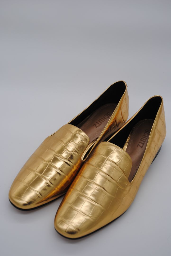 Side profile of designer women's gold loafers.