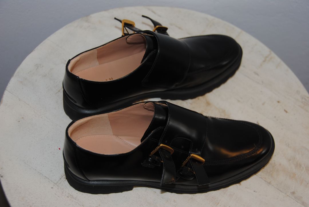 black and gold Cole Haan loafers with buckle