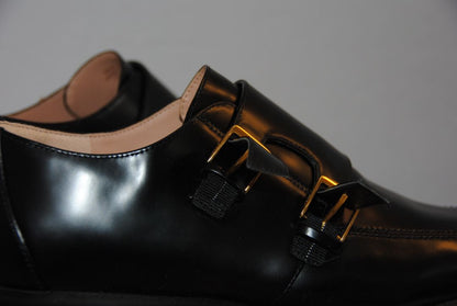 black and gold Cole Haan loafers with buckle