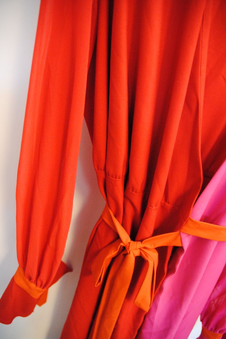 pink and red Marina Rinaldi Persona designer dress, Bust: 22.5 in (flat) Waist (adjustable tie): up to 21 in Hip: 24 in Length: 50 in (shoulder to hem) Sleeve Length: 24.5 in Fit: Relaxed wrap fit with tie belt