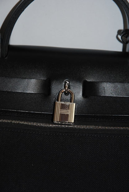 Black Canvas & Vache Hunter Leather with Palladium Hardware Hermes Hermès Herbag Zip 31 Retourne, Length: 12.25 in (31 cm) Height: 10 in (25 cm) Depth: 4.25 in (11 cm) Handle Drop: 2 in Strap Drop: Adjustable, up to 18 in (crossbody or shoulder)