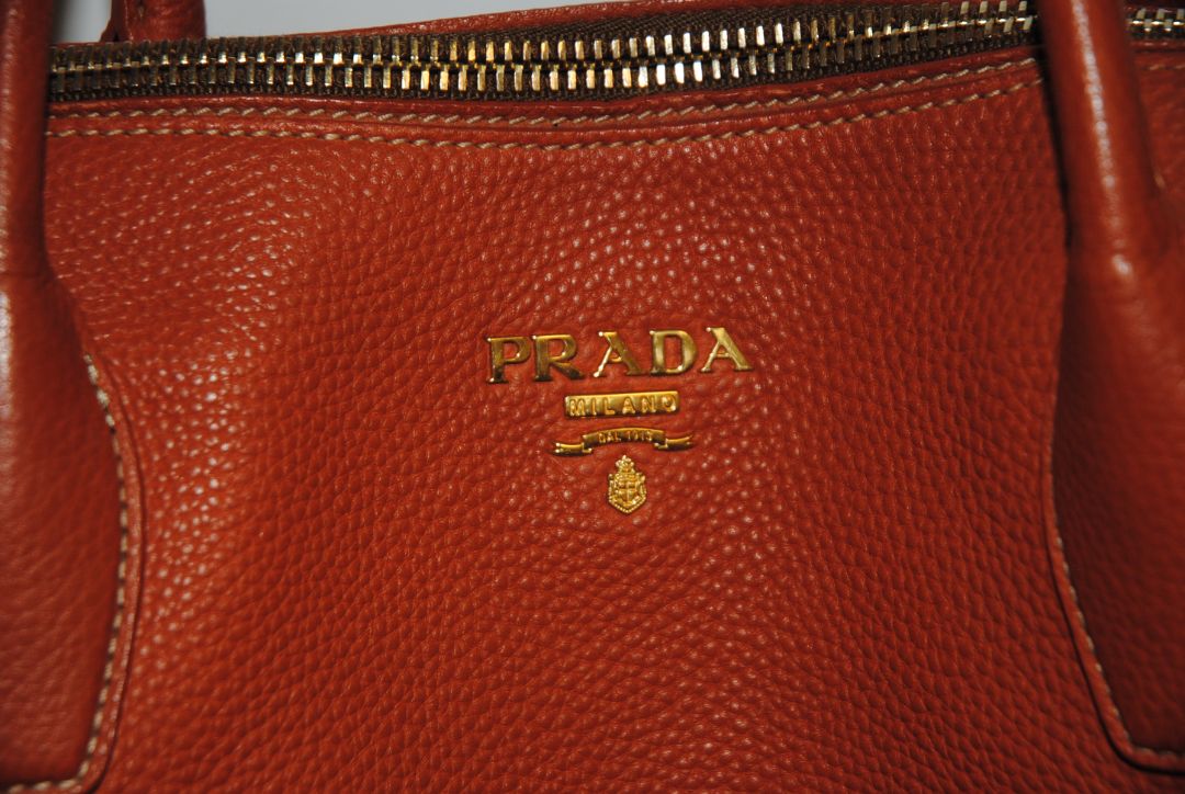 Burnt Orange / Papaya Prada Vitello Daino Zip Tote with Shoulder Strap, Length: 13.5 in (34 cm) Height: 10.5 in (27 cm) Depth: 6.5 in (17 cm) Handle Drop: 7.5 in (19 cm) Strap Drop: Up to 22 in adjustable