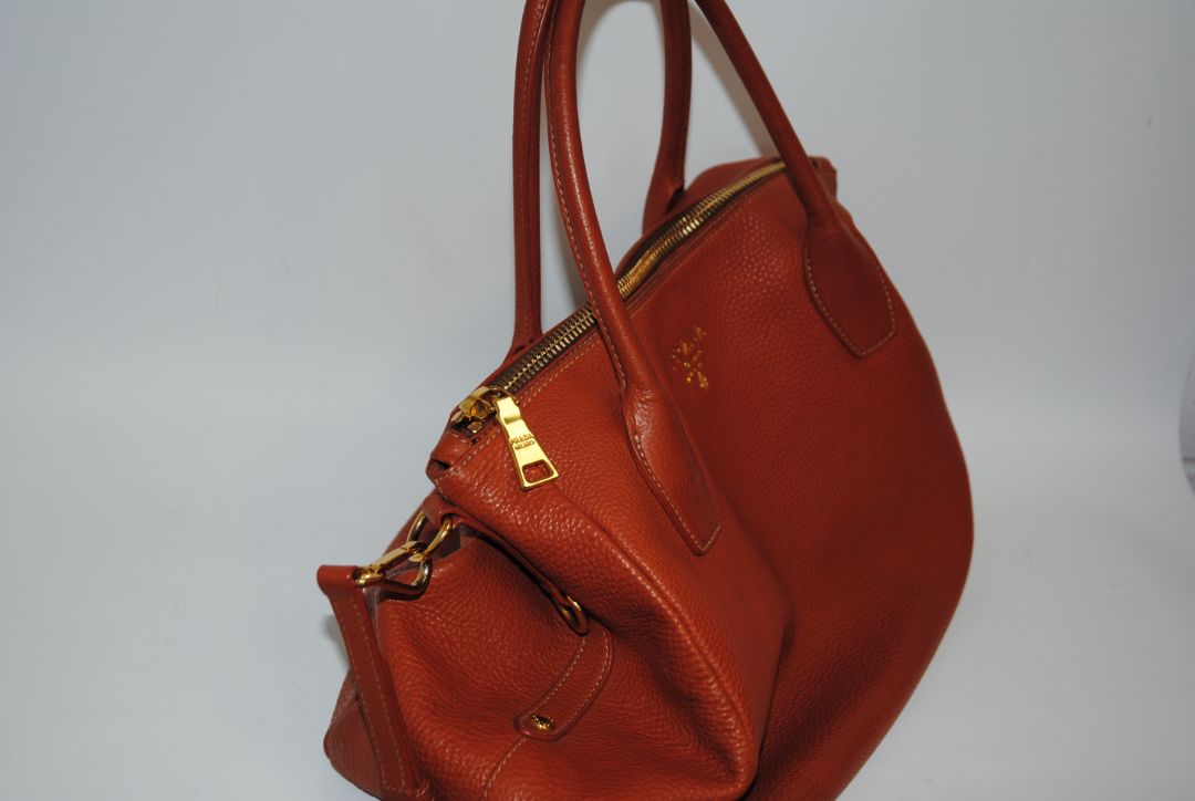 Burnt Orange / Papaya Prada Vitello Daino Zip Tote with Shoulder Strap, Length: 13.5 in (34 cm) Height: 10.5 in (27 cm) Depth: 6.5 in (17 cm) Handle Drop: 7.5 in (19 cm) Strap Drop: Up to 22 in adjustable