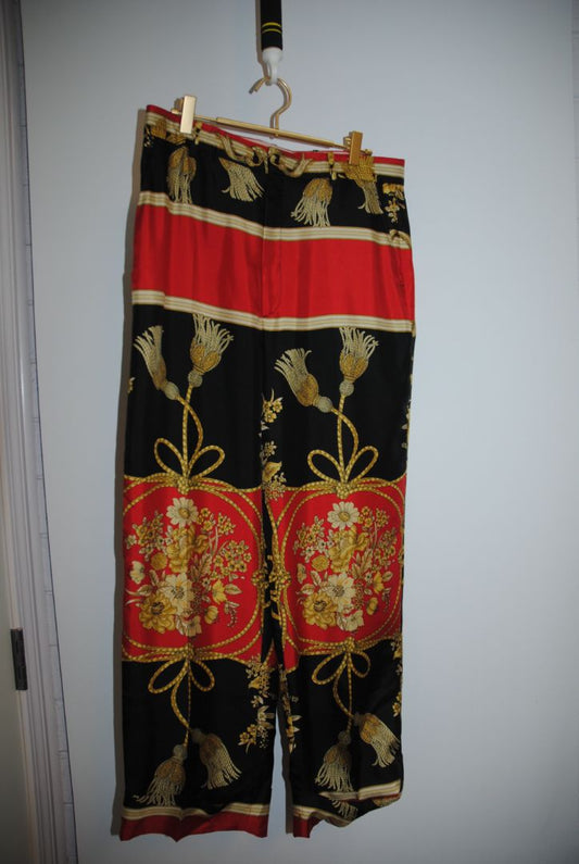 multi color Gucci Wide‑leg trousers with scarf‑print/baroque motif (gold/gilt scrolls/florals, rope/tassel detail), Waist approx. 30–34 in (depending on size) Inseam approx. 28–30 in (for a full-length wide leg) Leg‑opening width wide (perhaps 10–14 in ac
