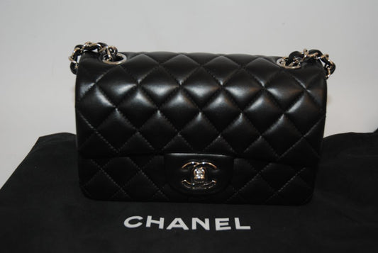 black lambskin Chanel classic flap bag, approx 25.5 cm (W) × 16 cm (H) × 7 cm (D) (≈ 10″ × 6.3″ × 2.75″) per size guide.