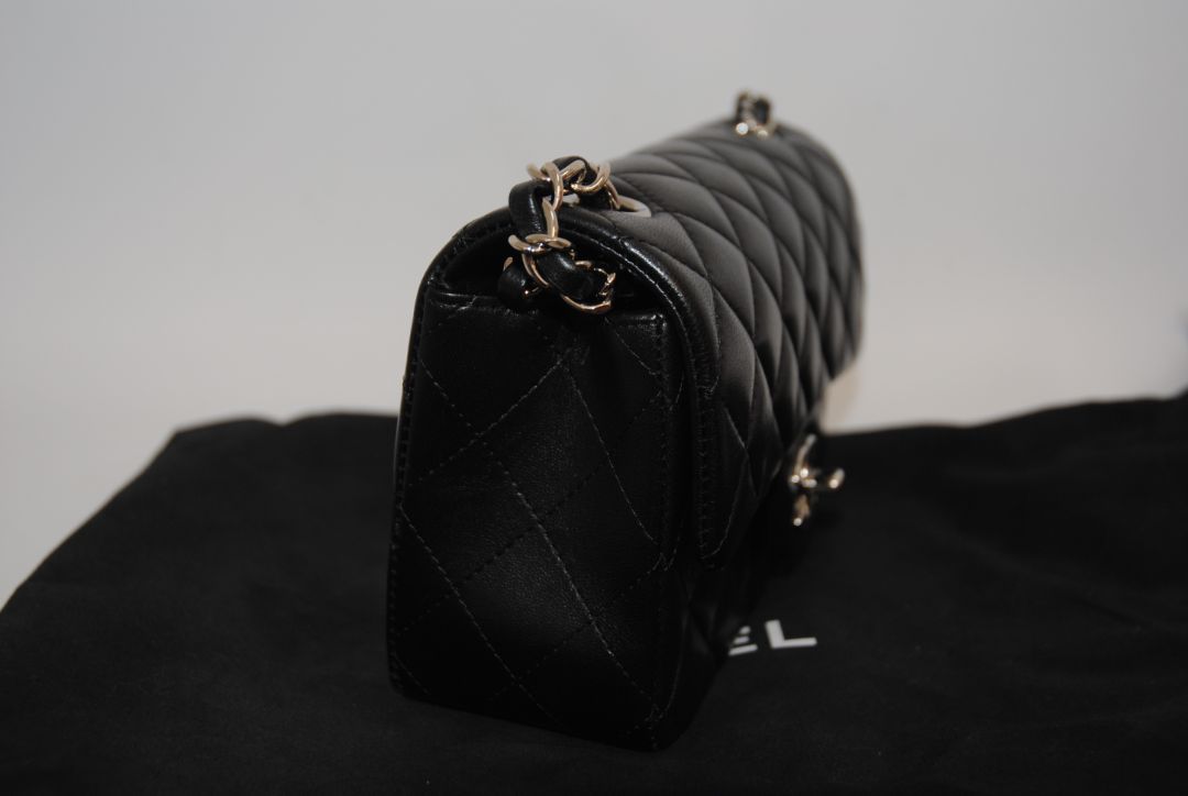 black lambskin Chanel classic flap bag, approx 25.5 cm (W) × 16 cm (H) × 7 cm (D) (≈ 10″ × 6.3″ × 2.75″) per size guide.