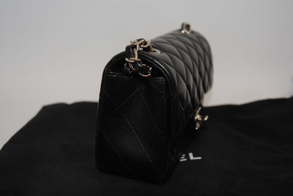 black lambskin Chanel classic flap bag, approx 25.5 cm (W) × 16 cm (H) × 7 cm (D) (≈ 10″ × 6.3″ × 2.75″) per size guide.