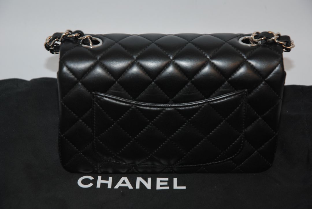 black lambskin Chanel classic flap bag, approx 25.5 cm (W) × 16 cm (H) × 7 cm (D) (≈ 10″ × 6.3″ × 2.75″) per size guide.
