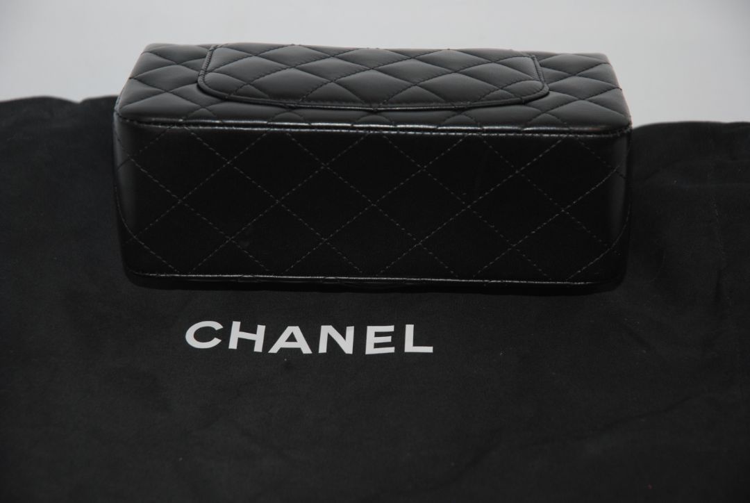 black lambskin Chanel classic flap bag, approx 25.5 cm (W) × 16 cm (H) × 7 cm (D) (≈ 10″ × 6.3″ × 2.75″) per size guide.