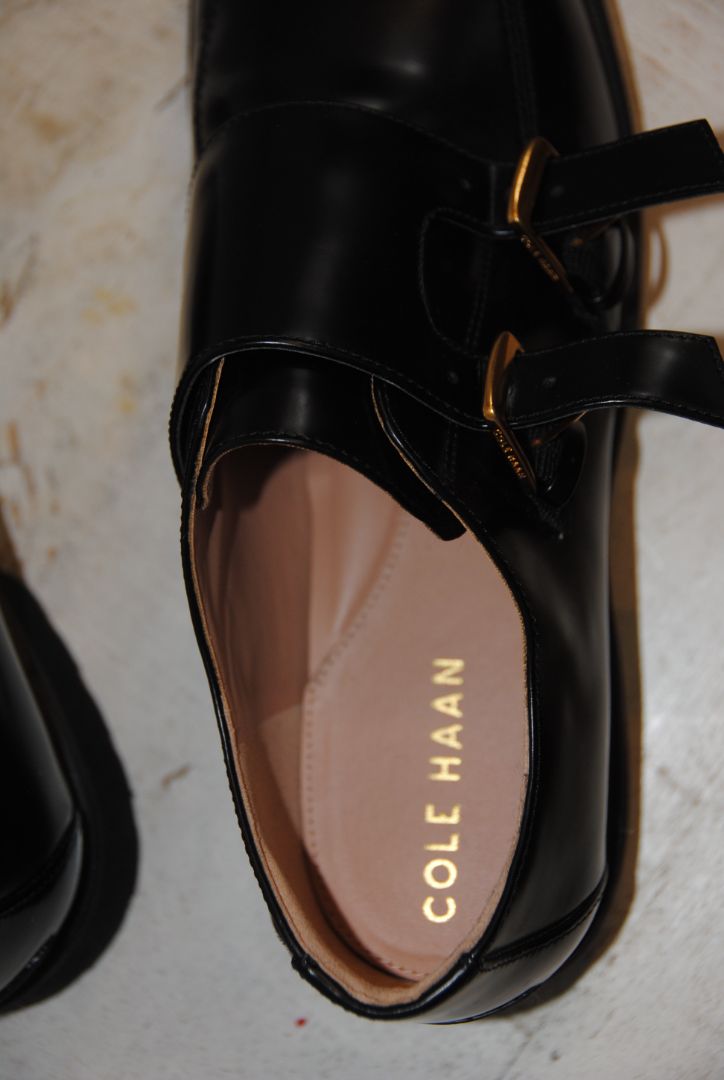 black and gold Cole Haan loafers with buckle