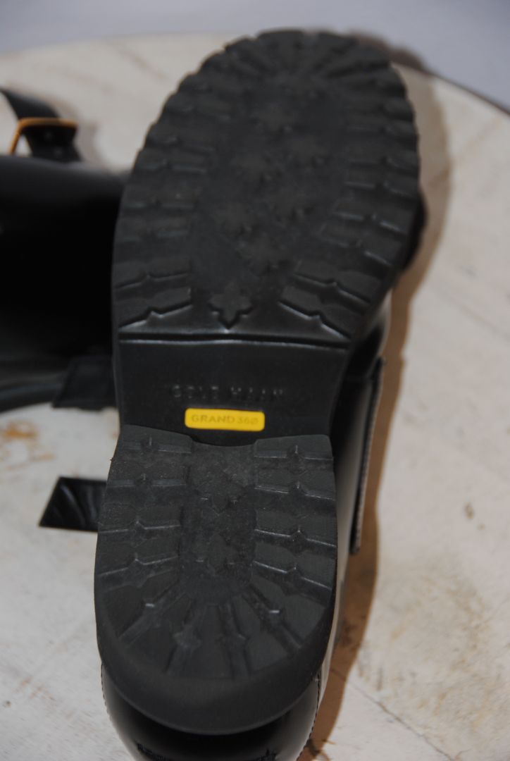black and gold Cole Haan loafers with buckle