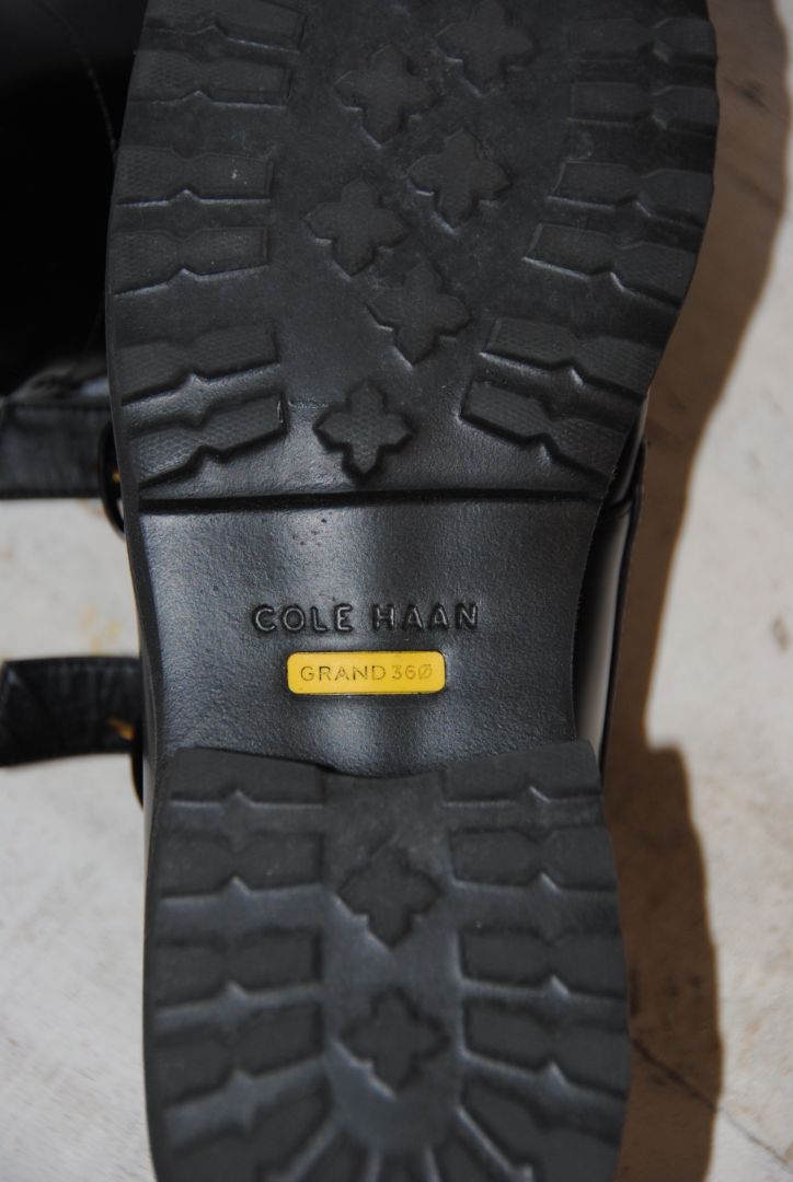black and gold Cole Haan loafers with buckle