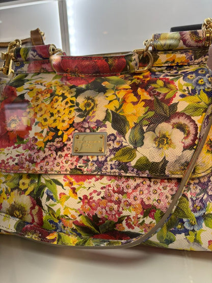 Side view of Dolce & Gabbana floral Dauphine bag with structured shape and leather top handle