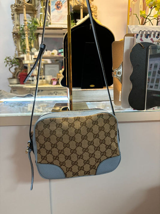 Gucci Bree Messenger Bag in blue dollar calfskin and beige GG Supreme canvas with adjustable strap and gold-tone hardware.