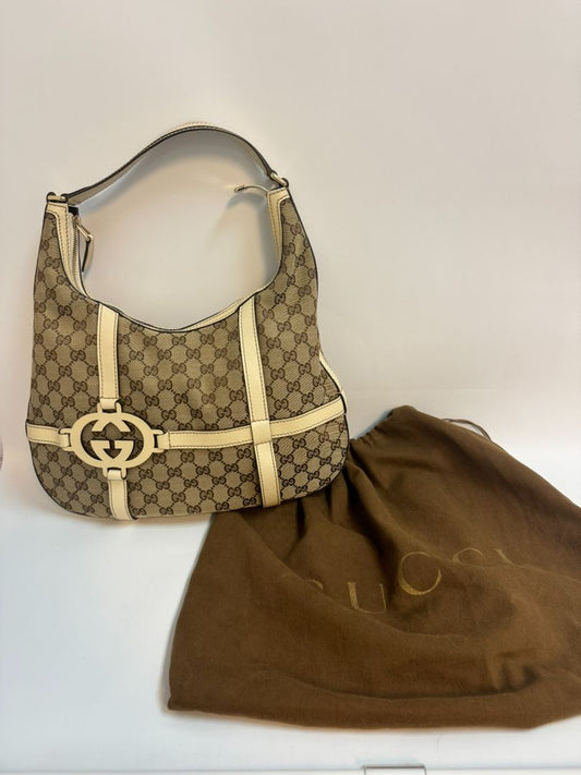 Gucci Monogram GG Royal Hobo bag in off-white, featuring the iconic GG monogram canvas, a soft hobo silhouette, and brown leather trim. The bag is accented with gold-tone hardware and a spacious interior, making it a stylish and practical choice for everyday wear.