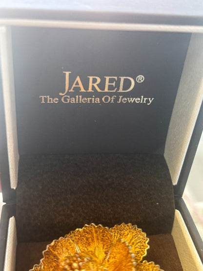 gold tone Jared brooch, Dimensions (Estimated from visual cues) • Diameter: ~2 inches (5.08 cm) • Height: ~1 inch (2.54 cm) • Weight: Unknown, but likely lightweight due to filigree structure