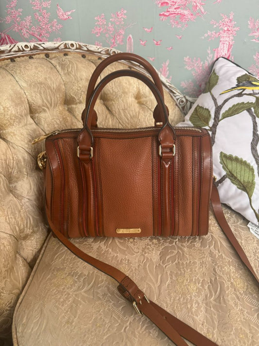 Cognac brown with multi-stripe accents in oxblood, black, and tan (subtle nod to Burberry’s house check palette) Burberry Model: Likely from the Banner or Orchard satchel line (structured silhouette with rolled handles and stripe accents), Length: 13 in (