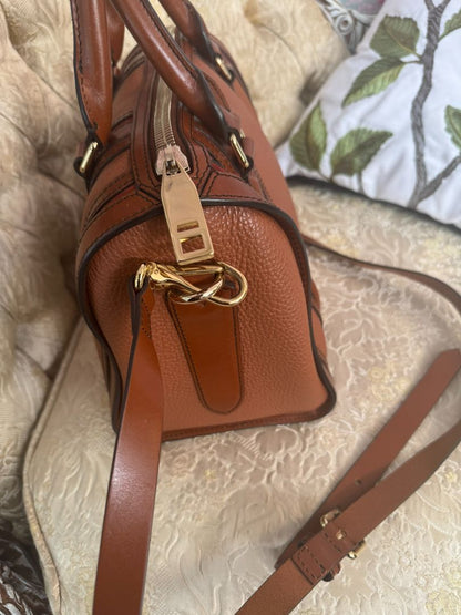 Cognac brown with multi-stripe accents in oxblood, black, and tan (subtle nod to Burberry’s house check palette) Burberry Model: Likely from the Banner or Orchard satchel line (structured silhouette with rolled handles and stripe accents), Length: 13 in (