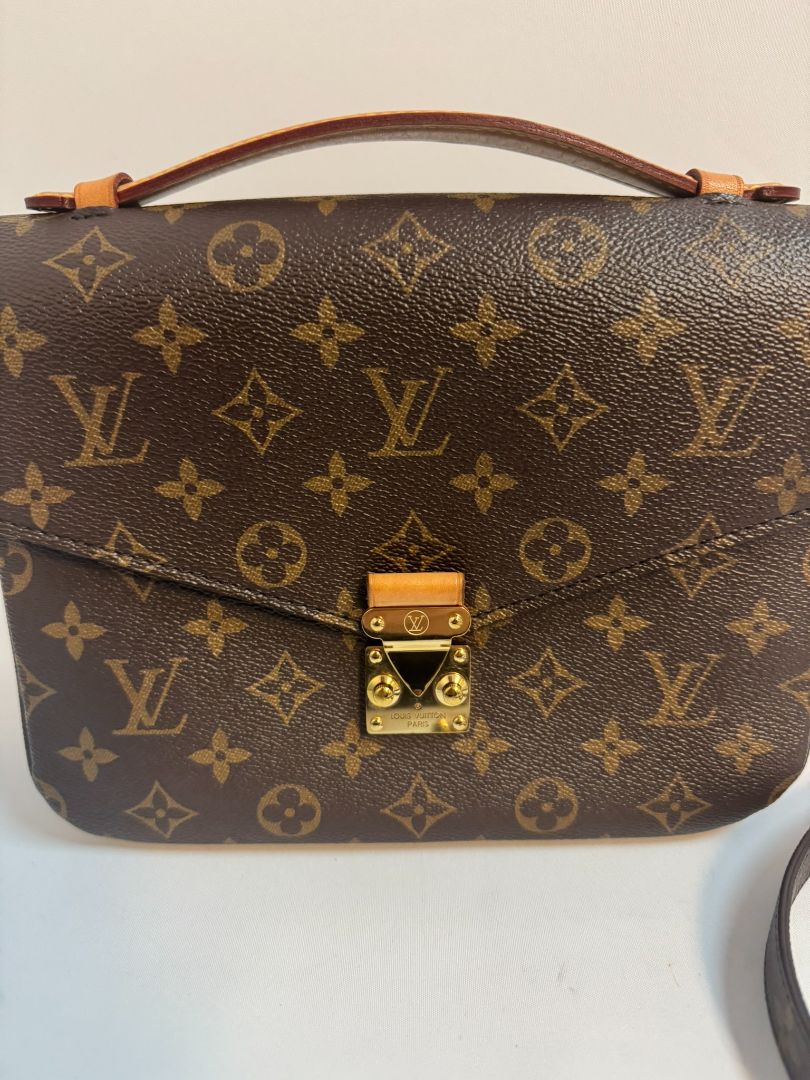 Louis Vuitton Pochette Métis in Monogram canvas, featuring the iconic LV logo print, a structured flap design, gold-tone hardware, and a detachable shoulder strap for versatile wear. This elegant crossbody bag is perfect for both day and night occasions.
