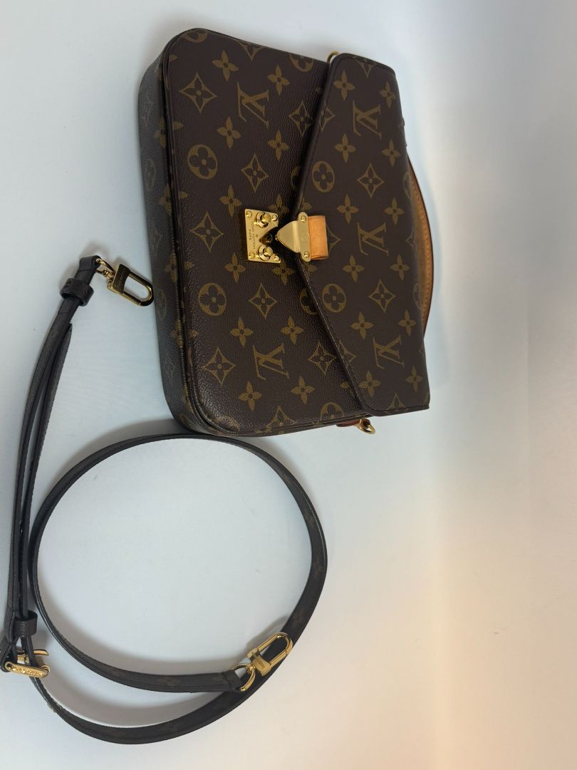 Louis Vuitton Pochette Métis in Monogram canvas, featuring the iconic LV logo print, a structured flap design, gold-tone hardware, and a detachable shoulder strap for versatile wear. This elegant crossbody bag is perfect for both day and night occasions.