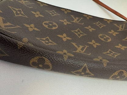 Louis Vuitton Pochette Monogram clutch bag with iconic brown monogram canvas and gold-tone hardware.