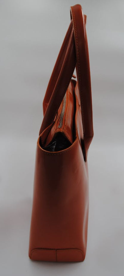 Side view of TOD'S D-Bag orange tote showing soft structured shape and pebbled Italian leather